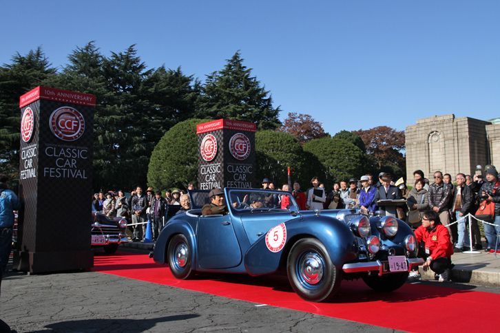 4台の戦前車に続いてスタートした、日本では非常に珍しい1947年「トライアンフ1800ロードスター」。2座ロードスターだが、トランクルームにランブルシート（折り畳み式の補助席）を備え、4人乗車が可能。パレード時も4人乗っていた。