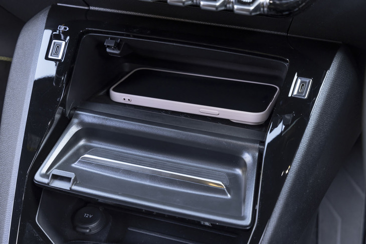 鍵盤スイッチの下にあるスマートフォンのワイヤレス充電器。普段はふた（手前のグレーの部分）をしておけるのがスマートだ。