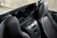 ソフトトップは左右シート間のレバーを上げると、ばねの力で写真のように跳ね上がる。小柄な人が、座ったままでも操作できるようにするための工夫だ。
    