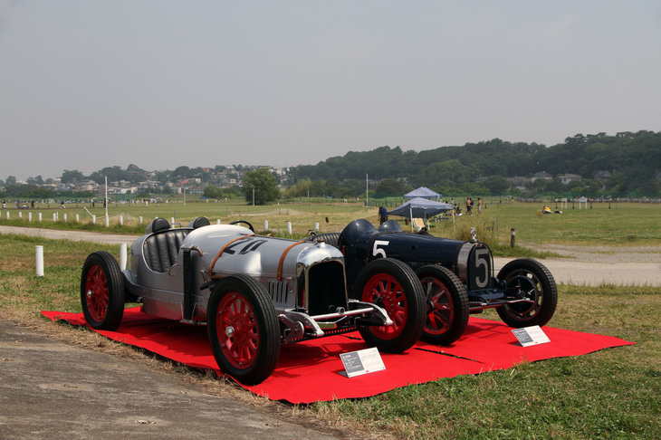 実際に多摩川スピードウェイで開かれたレースに参戦し、現存する2台のマシン。左は本田宗一郎が勤務していたアート商会が製作した1924年「カーチス号」。航空機「カーチス号」用8.2リッターV8エンジンを積んだスペシャルで、レースには宗一郎もメカニックとして同乗した。右の1926年「ブガッティT35C」は1.9リッター直8スーパーチャージドエンジンを搭載。どちらも現在はホンダコレクションホールの所蔵車両。