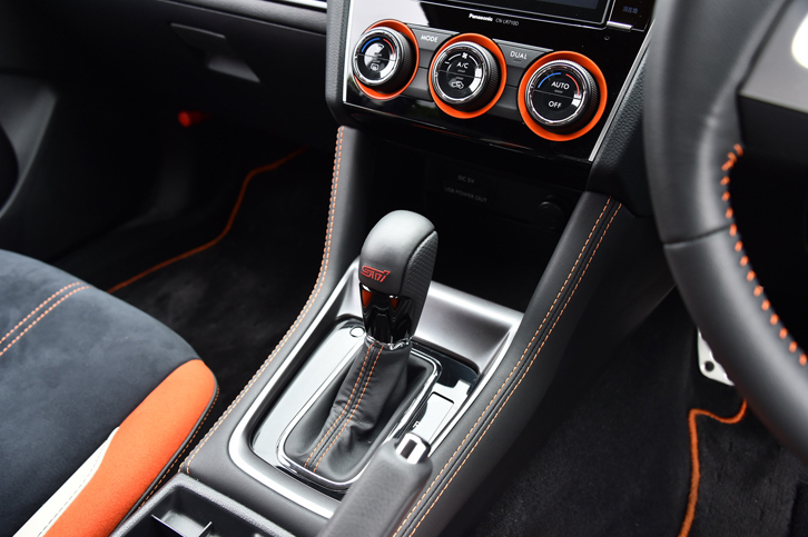 シフトレバーのブーツやステアリングホイールのステッチ、エアコンの調節ダイヤルなどにはオレンジの差し色が使われる。