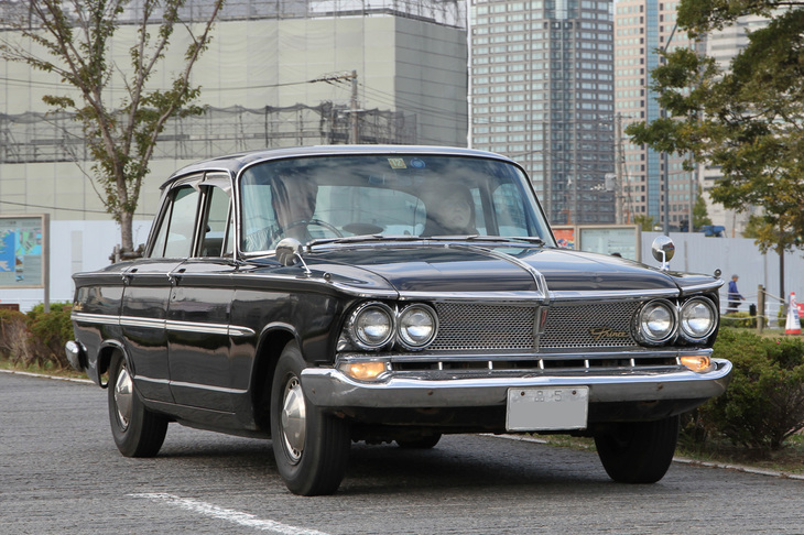 新車からの「品5」ナンバー付きの1963年「プリンス・グロリア デラックス」。1962年に、このデラックスのみのモノグレードで登場した2代目グロリアの希少な最初期型。後に追加された「スーパー6」が2リッター直6 SOHCを積んでいたのに対し、初代グロリアから受け継いだ1.9リッター直4 OHVエンジンを搭載。