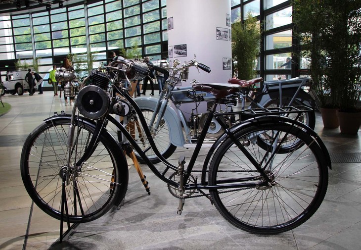 「オットー原動機付自転車」。脇に添えられた新車当時の広告には、「エンジンを切った状態でも普通の自転車として走行可能」との説明が。