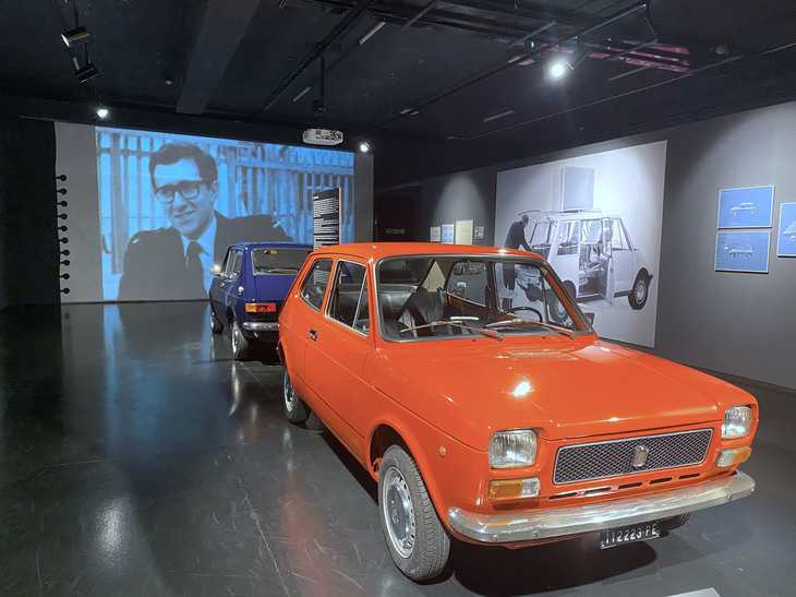 「フィアット127」。後方スクリーンにはデザイナー、ピオ・マンズー氏の姿が。2021年、トリノ自動車博物館の企画展で。