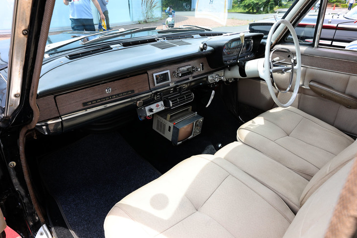 「プリンス・グランド グロリア」の前席。木目化粧板張りのインパネやリクライニングするセパレートシートは専用装備。フロアトンネル上に車載可能をうたっていたSONYのマイクロテレビが後付けされている。