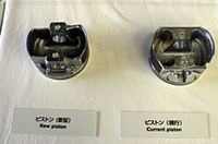 
	新旧のピストン比較。左の新型は左右非対称なのがわかる。これはシリンダー壁面に押しつけられる側（右側）に強度を持たせつつ、逆側は小さくしてフリクション低減を狙ったもの。
	 