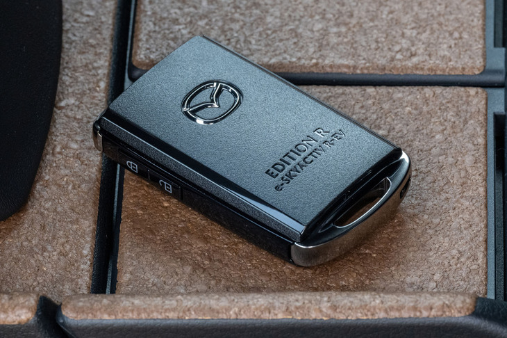 「8C」型ロータリーエンジンのローター曲面とアペックスシール部分の形状を再現したキーフォブ（写真）は、特別仕様車「MX-30エディションR」の専用アイテム。
