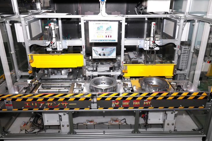 ステータコアと内部で回転するローターは、1枚の金属板から打ち出されたパーツを何枚も積み重ねてつくる。こちらはステータコアのワイヤーを挿す穴に絶縁紙を挿し込む工程。