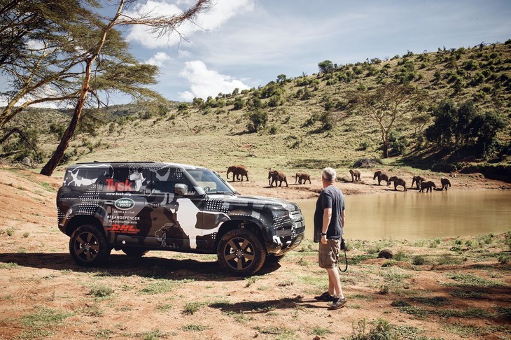 カムフラージュ塗装が施された新型「ディフェンダー」。傍らに立つのはフォトグラファーのデイビット・ヤーロー氏。