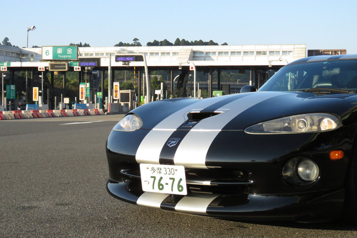 東金ICにて記念撮影。写真のようなETC対応の料金所は問題ないが、例えば箱根のターンパイクや九十九里有料道路のそれのように、自動で通行料の支払いができない料金所は厳しい。「バイパー」は左ハンドルな上に、“くまもん体形”の記者にとっては、乗降が地味に大変なのだ。