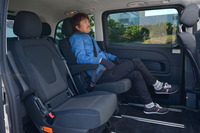 2列目シートを最も後方にスライドさせた様子。身長175cmの筆者が足を組める空間が生まれる。スライドドアの大きな窓ガラスは固定式で、開閉することはできない。