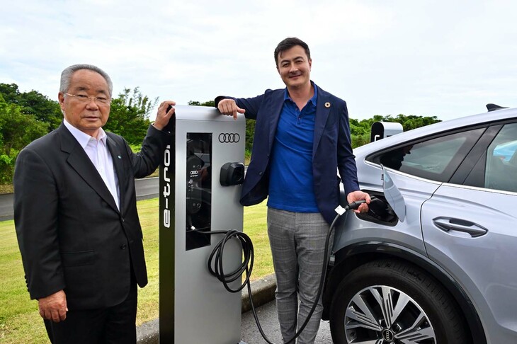 屋久島町役場に新たに設置された充電器で、「アウディQ4 e-tron」に充電するシェーパース氏と荒木町長。