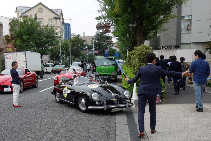 会場の入り口にて、参加車両の1954年式「ポルシェ356スピードスター」を誘導するオフィシャルのスタッフ。こうしたイベントを支える、縁の下の力持ちである。