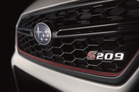 メッシュタイプのフロントグリル。STIのイメージカラーとしておなじみの、チェリーレッドのストライプが添えられる。