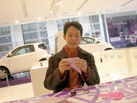 自動車業界の復興を願い、心をこめて鶴を折る筆者。