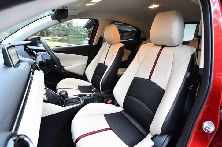 「デミオ」の上級グレード「XDツーリング Lパッケージ」には、オフホワイトのレザーにブラックのファブリック、赤のアクセントが組み合わされたシートが与えられる。