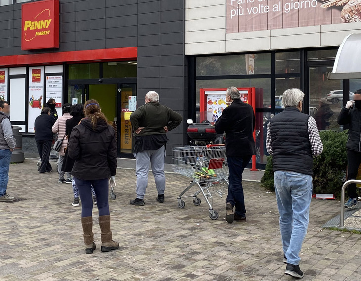 小売り活動の休止に関する首相令が発動された初日（2020年3月12日）の朝、シエナ市内のスーパーは、政府の指導により、一度に店内に入る客数を制限していた。来店客は冷静に外で待っている。
