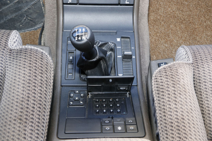 1990年式。シフトレバーの手前にあるキーボードで盗難防止用暗証番号を入力してから、キーを回してエンジンを始動する。右は車高調整用レバー。