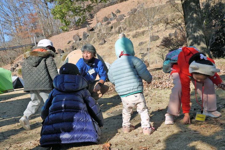 和田さんとどんぐりを拾う子供たち。地面にはシラカシやコナラ、クヌギのどんぐりがそこら中にちらばっている。
