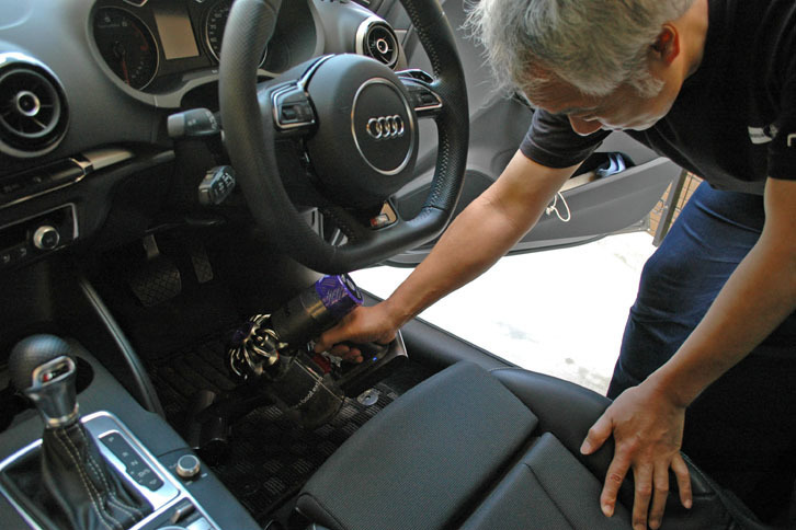 近所のアウディオーナーさん。毎週土曜日の朝4時30分に起きて洗車をするのが趣味だという。「Dyson V6 Car + Boat Extra」の吸引力に驚きの表情を見せながらも、きれいになっていくのを見てニヤニヤしていた。（著者撮影）