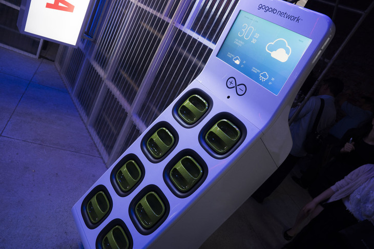 会場にはバッテリー交換ステーション「GoStation（ゴーステーション）」も展示されていた。この2列4段のキャビネットをベースに、設置場所によっては複数のキャビネットをつなぎ合わせてステーションを形成する。スマートフォンと連携しており、空きスロットにバッテリーを差し込むと充電済みバッテリーが提供される仕組みだ。