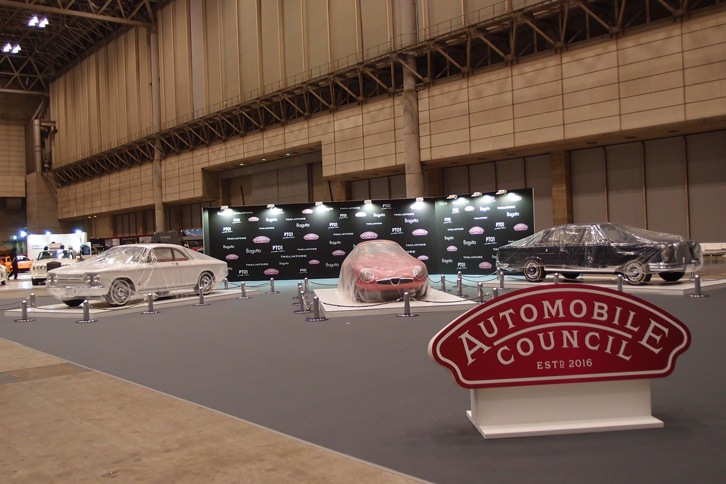 会場入り口付近の「主催者コーナー」では、カバーをかけられた3台のクラシックカーが開会のときを待つ。写真左から「シボレー・コーヴェア モンザ」（1963年）と「アルファ・ロメオ・ジュリアTZ」（1965年）、「メルセデス・ベンツ220SEb」（1961年）。