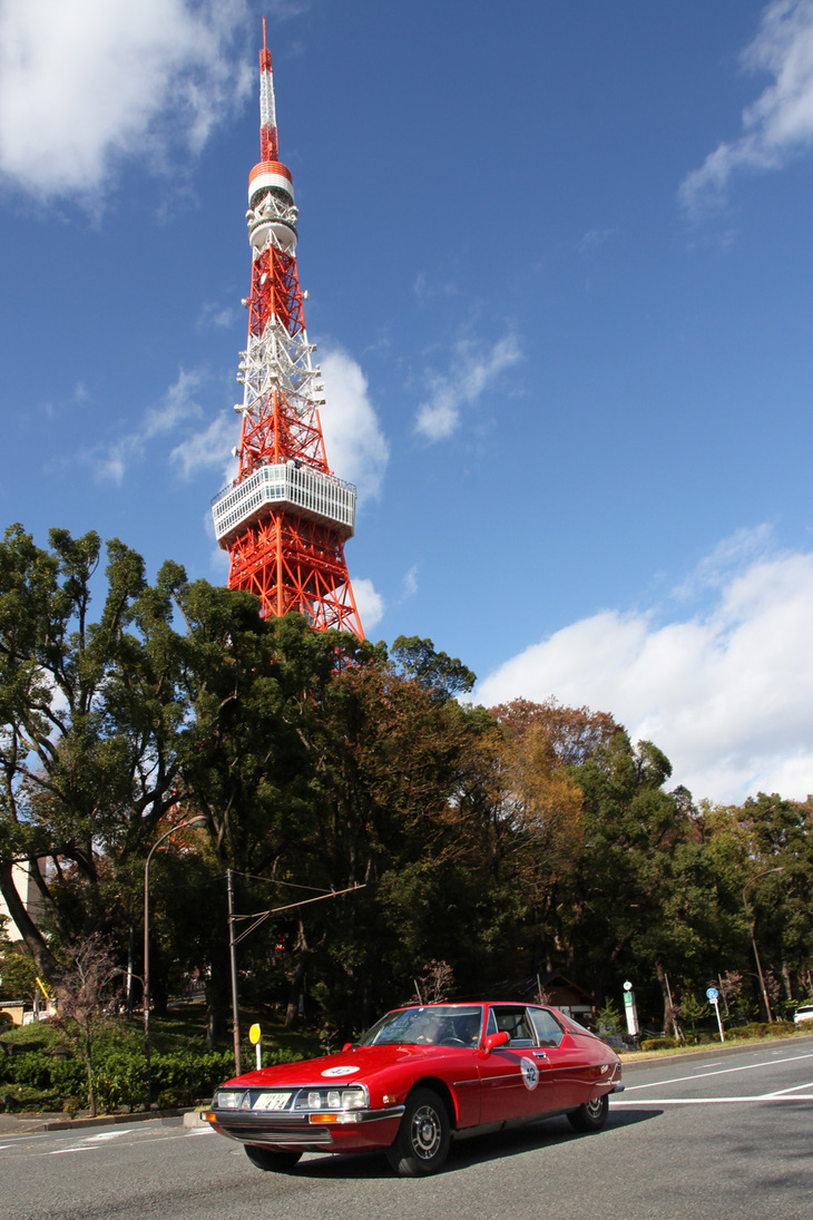 秋空にそびえ立つ東京タワーの下を抜けて行く、真っ赤な1975年「シトロエンSM」。
