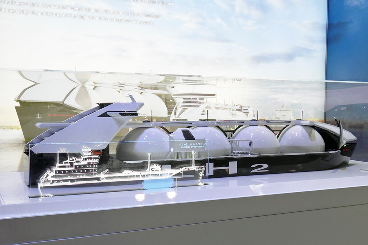 中型液化水素運搬船の模型。ガラスケースには、比較用に現行の水素運搬船「すいそふろんてぃあ」の線画が同縮尺で描かれている。