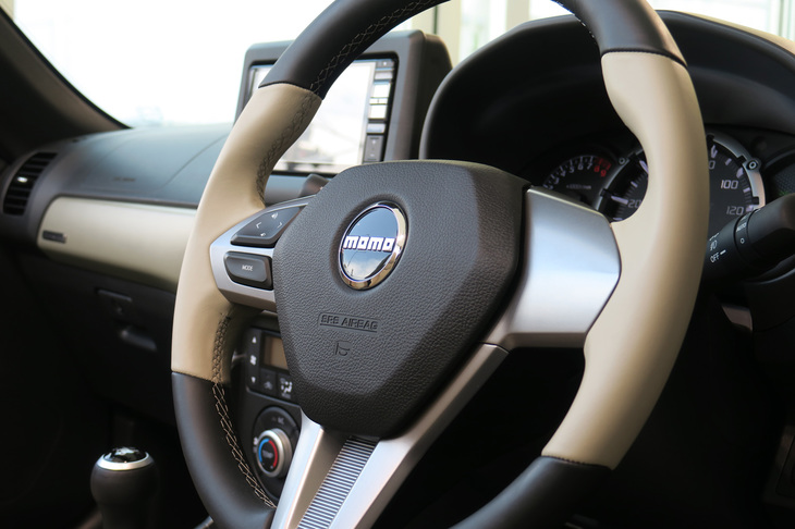 アイボリーとブラックのツートンカラーが特徴的な、MOMO製専用本革巻きステアリングホイール。メッキのオーナメントも目を引く。