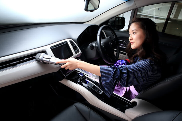 「延長ホース」を使ってダッシュボードのホコリをやっつけたら、そのままエアコンの吹き出し口も清掃。コードレスでボディーも小さいので、取り回しで苦労しないのがいいですね。