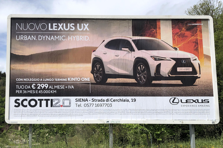 イタリアにおける「レクサスUX」の街頭広告。「KINTO」なら月299ユーロ（約3万9000円。付加価値税22％を含まず）とうたっているが、下端には当地の表示規則にしたがい、細かい解説が。2021年に撮影。