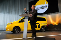 「NV200ニューヨークタクシー」を披露する日産自動車のアンディ・パーマー副社長。（写真＝日産自動車）