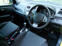 インストゥルメントパネルとドアトリムにヘアラインメタル調の処理が施された室内。シートやステアリングホイール、シフトブーツには赤いステッチが入る。