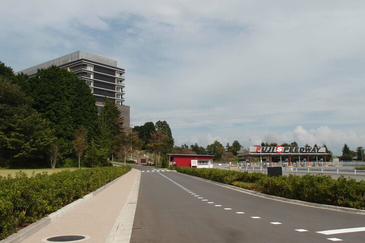 富士スピードウェイを訪れたことのある人にはおなじみの西ゲート。その西隣に、富士スピードウェイホテル（写真左奥）は建設された。真新しいアプローチ路がエントランスへと続く。