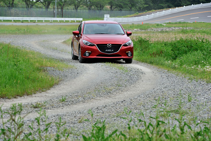 GVC搭載の「アクセラスポーツ15S」（FF）で砂利路を行く。