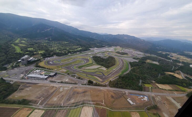 写真中央がレーシングコースで、左端に見えるのが富士スピードウェイホテル。手前に広がる更地には今後、レーシングチームのガレージやレストラン、温浴施設が建設される計画だ。この地の開発にかかわるトヨタ自動車および富士スピードウェイ、トヨタ不動産は、人生をより豊かで幸せなものにしてもらえる“大人の遊び場・社交場”をテーマに、「未来のモビリティー・モータースポーツの街」を創出しようとしている。