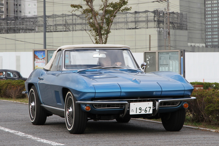 会場へのアプローチロードを行く1967年「シボレー・コルベット スティングレイ」。C2こと2代目コルベットの最終モデル。