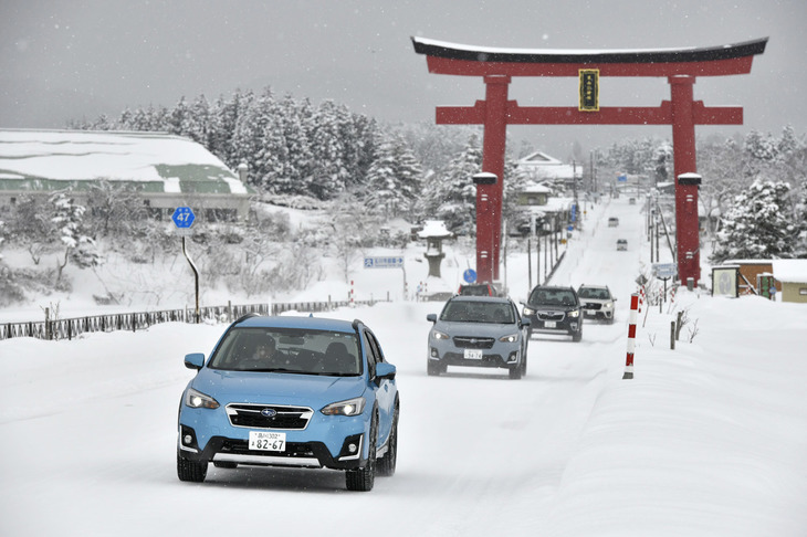 出羽三山神社の鳥居下を走るスバルテックツアーの試乗車両。