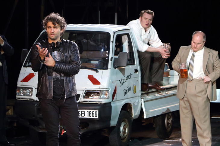 2016年6月、バイエルン国立歌劇場『ニュルンベルクのマイスタージンガー』で。現代的読み替え演出にも果敢に挑む。参考までに、後方の車両は「ダイハツ・ハイゼット」をベースに伊ピアッジオ社が生産した「ポーター」。