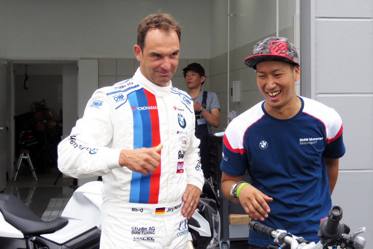 サービス棟の前で談笑するヨルグ・ミューラー選手（左）と小川裕之選手（右）。ミューラー選手は小川選手がライディングした「BMW F800R」に興味津々（しんしん）の様子。次々に投げかけられる質問に、小川選手も英語で答えていた。