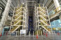 金型交換の時間を短縮するために新設された自動金型ラック。左右の棚に全157種類の金型が収められており、搬出、搬入には大型のクレーンを使う。この設備の導入により、これまで30分以上かかっていた金型交換の「前段取り」と呼ばれる作業の時間は、約10分に短縮された。棚の耐荷重は40tで、震度6の地震に耐える設計となっている。