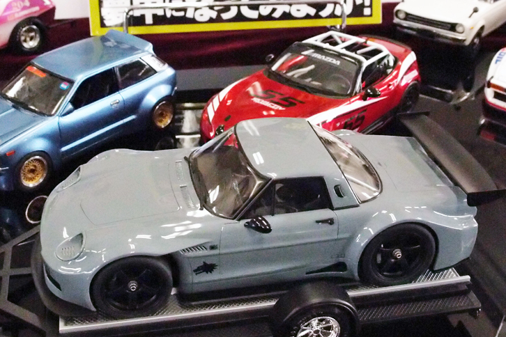 前出の“サバンナ・セダン”がけん引するトレーラーに載せられていた謎のマシン。キャビンまわりは「コスモスポーツ」のようだが……。ハセガワ製1/24「マツダ・コスモスポーツ」とフジミ製1/24「BMW Z4 GT3」を上下方向に合体し、仕上げたというアイデア賞ものだった。