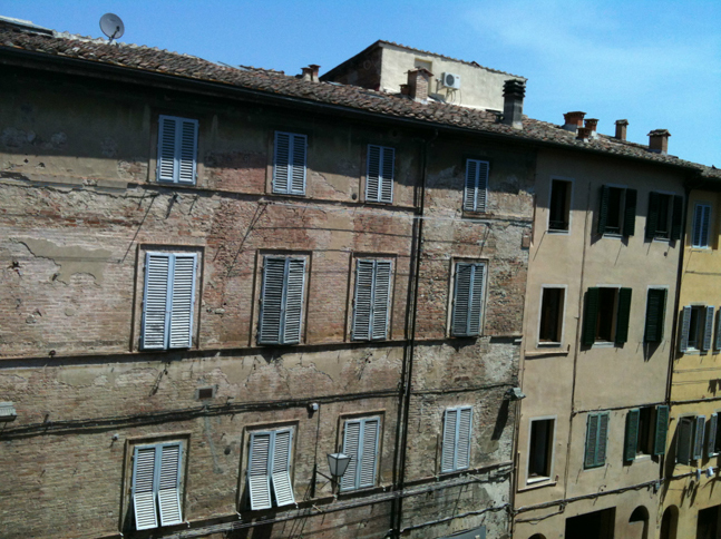 シエナ旧市街にある、4年前まで筆者が住んでいた家からの風景。昼間だというのに、ほとんどの家がペルシアーナを閉めたままである。