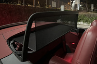 走行中の風の巻き込みが最小限に抑えられる電動ウインドディフレクターを装備。スイッチひとつですぐに立ち上がる。ソフトトップが閉じられると、展開したウインドディフレクターも連動し、自動的に格納される。