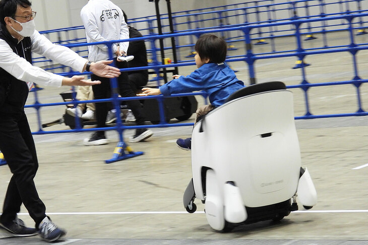 簡単な重心移動だけで操作できる「ホンダUNI-ONE」は、ご覧のとおり小さな子供でも運転が可能。ハンズフリーなので、歩行者と手をつないでの移動もできるという。ホンダでは近い将来の社会実装＆市販化へ向け、検証を進めているという。