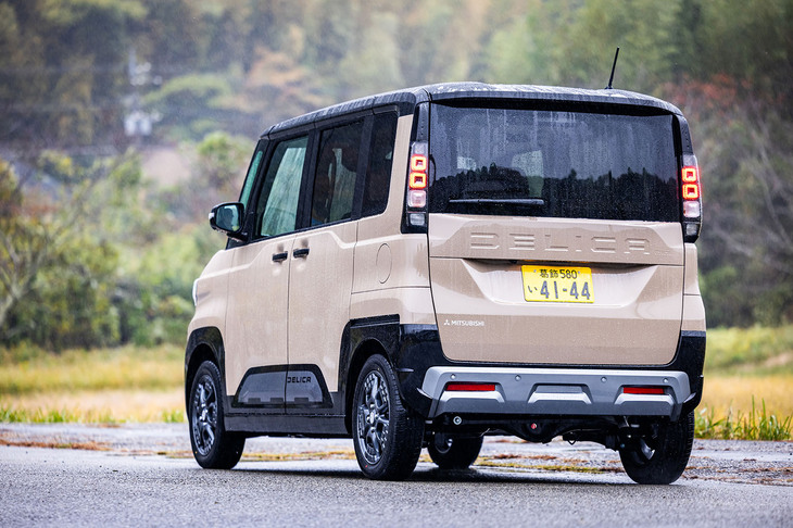 「デリカミニ」のリアスタイリング。大型化したスキッドプレートで、より強くアウトドアテイストを表現している。リアウィンドウ下に配置された「DELICA」の車名ロゴや、トレッキングシューズをモチーフとした新デザインアルミホイールの採用も新型における特徴だ。