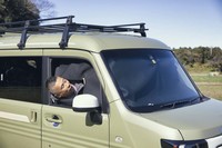 車内のプライバシーを守る「プライバシーシェード」を装着した様子。部分的に切れ込みがあり、装着したままでも写真のように内外のやりとりは可能。ルーフに取り付けられている専用キャリア（前後長158cm×幅115cm、耐荷重15kg）は3万3000円のオプション。