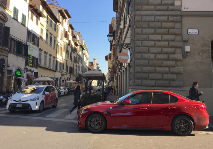 イタリアでも激レアな「アルファ・ロメオ・ジュリア クアドリフォリオ」（写真右）を見つけて撮っていたら、「プリウス プラス」（同左）のタクシーがやってきた。