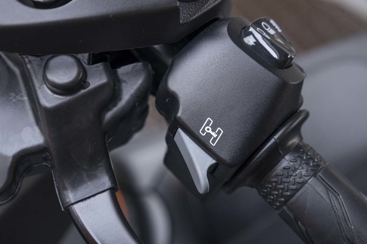 「スタンディングアシスト」のスイッチは左側のグリップ付近に配置される。作動状況は、メーター内のインジケーターに加え、ブザー音でも通知される。