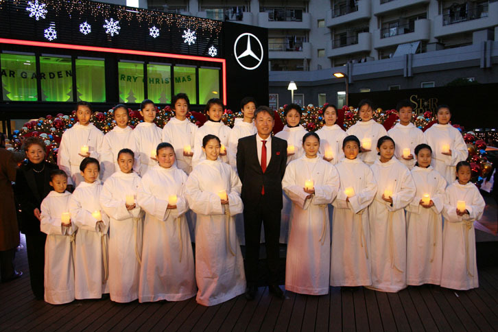 発表会で賛美歌を披露した東京少年少女合唱隊と、メルセデス・ベンツ日本の上野金太郎 代表取締役社長兼CEO（1列目の中央）。